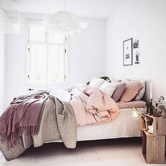 A Shaded Array Of Mauve, Gray, And Light Pink Blankets And Pillows