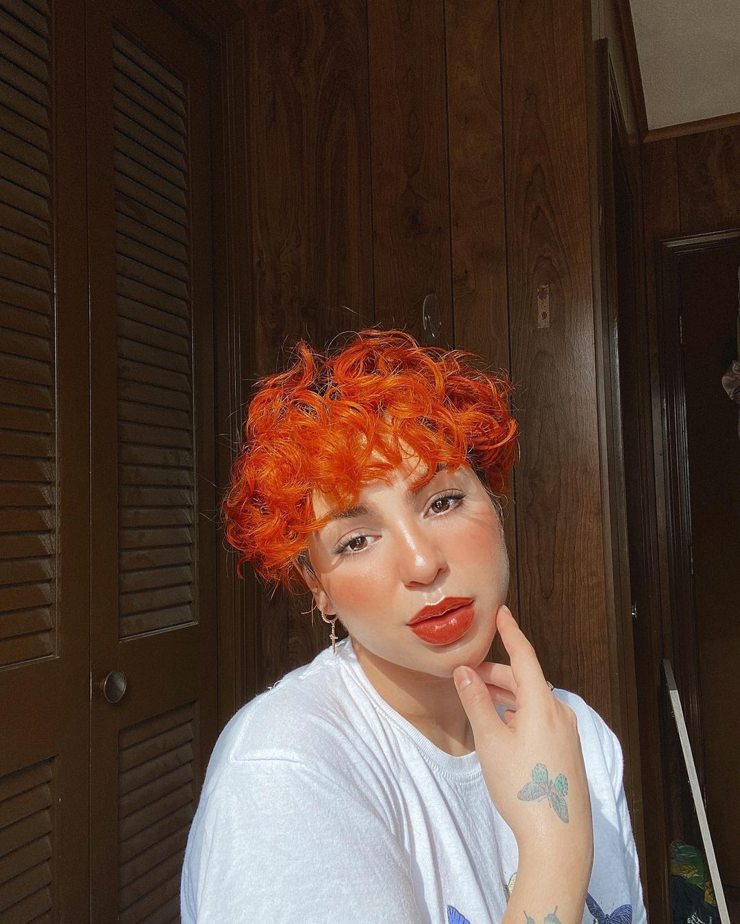 Short and Curly Undercut in Neon Orange Curly Pixie Cut