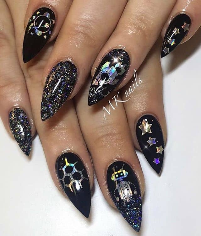 Glittery Black Stiletto Nails with Space-themed Decorations